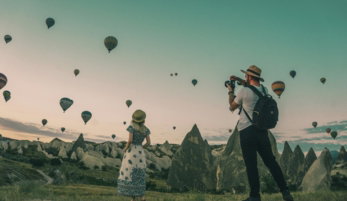 man taking photo of hot air balloons